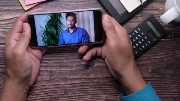 Akıllı telefon ekranında bir video konferans ekranında iş adamı — Stok video