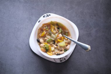  Siyah arka planda tavuk sebze çorbası.