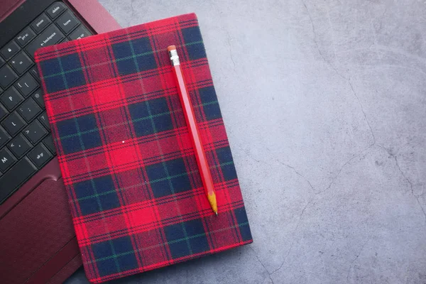 黒い背景の赤い色のノートパッド、鉛筆、ノートパソコン — ストック写真