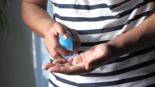 Homem jovem usando gel higienizador de mão interior — Vídeo de Stock