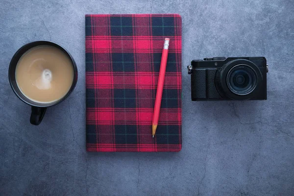 Classic camera with a red notepad and coffee on black background. — Stock Photo, Image