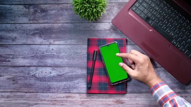 Vista de ángulo alto de la mano del hombre utilizando el teléfono inteligente con pantalla verde — Vídeos de Stock