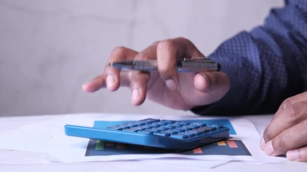 Крупный план руки человека с помощью калькулятора на рабочем столе — стоковое видео
