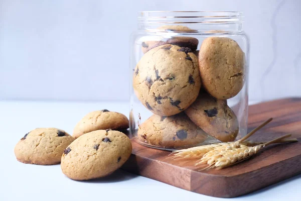 Barattolo pieno di biscotti con gocce di cioccolato su sfondo bianco — Foto Stock