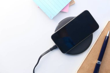 Kablosuz şarj pedi kullanarak akıllı telefon şarj ediliyor, üst görünüm 