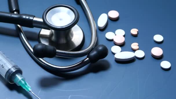 Close-up van pillen, spuit en stethoscoop op kleur achtergrond — Stockvideo