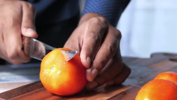 Ruka osoby bourání rajčata na řezací desce — Stock video