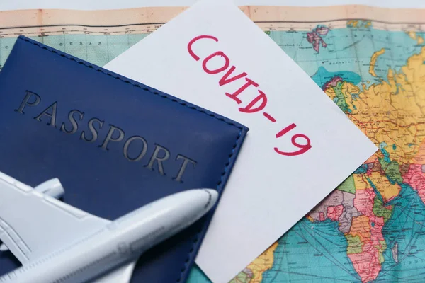 Poznámka COVID-19 koronavirus, cestovní mapa a modrý barevný pas na stole — Stock fotografie