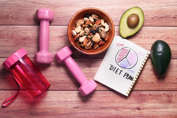 Diet plan with almond nut, dumbbells, avocado on table . — Stock Photo, Image