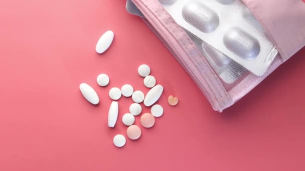 Белые таблетки и пузырь пакет на розовом фоне — стоковое видео