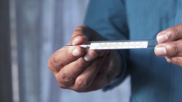 Mann hält medizinisches Thermometer in der Hand, Nahaufnahme. — Stockvideo