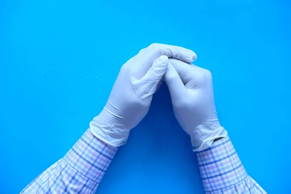Γιατρός χέρι με γάντι σε μπλε φόντο. — Φωτογραφία Αρχείου