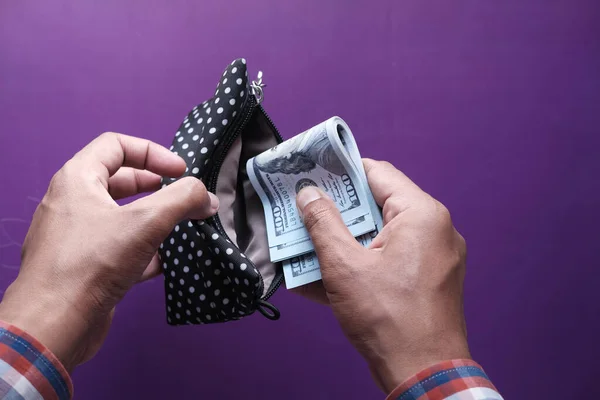 person hand putting cash in a a wallet