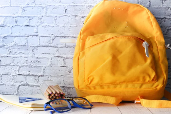 Back to school concept yellow backpack on table — Stock Photo, Image