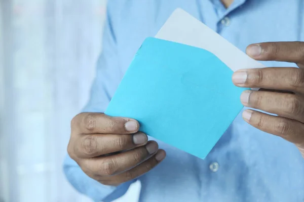 Primer plano de la mano del hombre sosteniendo sobre azul . — Foto de Stock