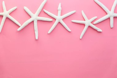 Pembe arka planda beyaz yıldız balıkları.