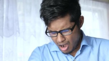 Genç hasta adam burnunu ve ağzını koluyla kapatıyor..