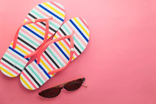 Sunglasses and sandals on pink background top down — Stock Photo, Image