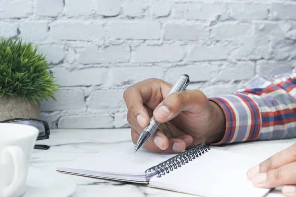 Close up de homem mão escrevendo com caneta no bloco de notas — Fotografia de Stock