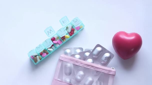 Embalagem blister, forma do coração e caixa de comprimidos sobre fundo branco — Vídeo de Stock