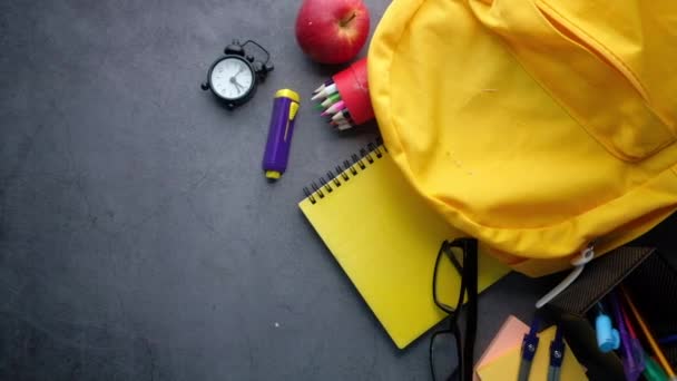 Voltar ao conceito da escola mochila amarela e fornecedores da escola em fundo preto — Vídeo de Stock