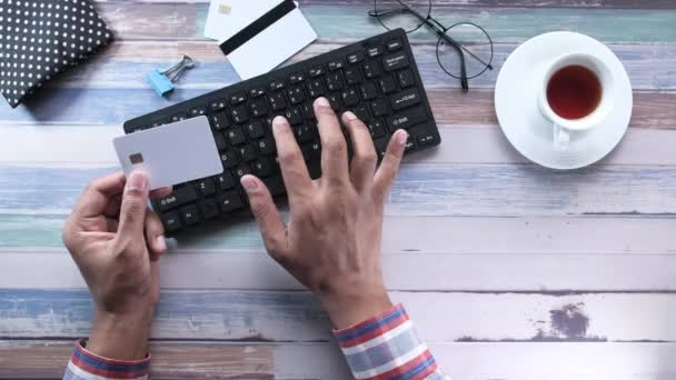 Homme mains tenant la carte de crédit et en utilisant le clavier achats en ligne — Video