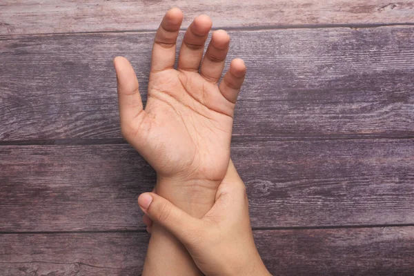 Junge Frauen Hände auf dem Tisch in Schmerzen am Handgelenk, Draufsicht — Stockfoto