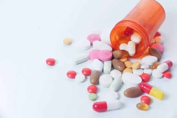 Primo piano di pillole colorate fuoriuscita dal contenitore — Foto Stock