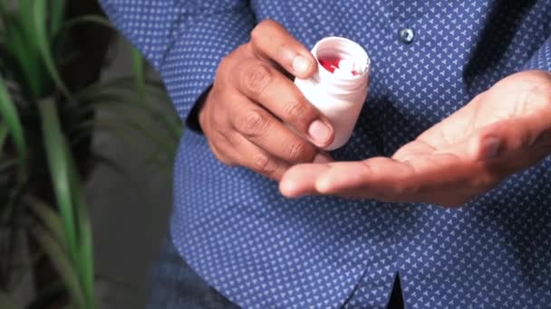 Крупним планом чоловік у повсякденній сорочці, приймаючи ліки — стокове відео