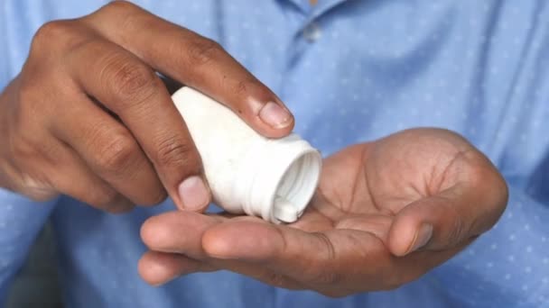 Közelkép férfi kezét figyelembe tabletták elszigetelt fekete — Stock videók