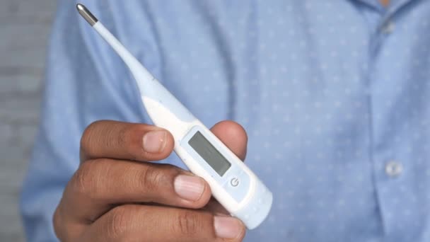 Mann hält digitales Thermometer in der Hand — Stockvideo