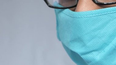 Koruyucu maskeli genç bir adam üzgün görünüyor. 