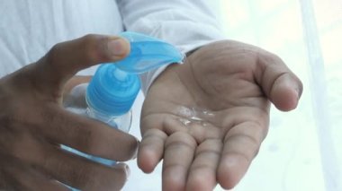 Siyah üzerine izole edilmiş dezenfektan jeli kullanarak insan elini kapat. 