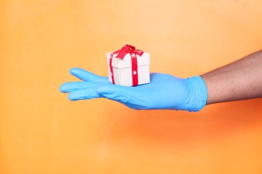 Mavi eldivenli erkek eli bir hediye veriyor..