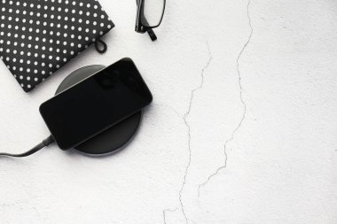 Kablosuz şarj pedi kullanarak akıllı telefon şarj ediliyor, üst görünüm 