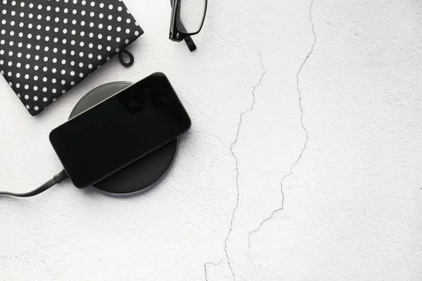 Kablosuz şarj pedi kullanarak akıllı telefon şarj ediliyor, üst görünüm 