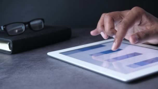 Dijital tabletteki finansal tabletleri analiz eden adamın elini kapat — Stok video