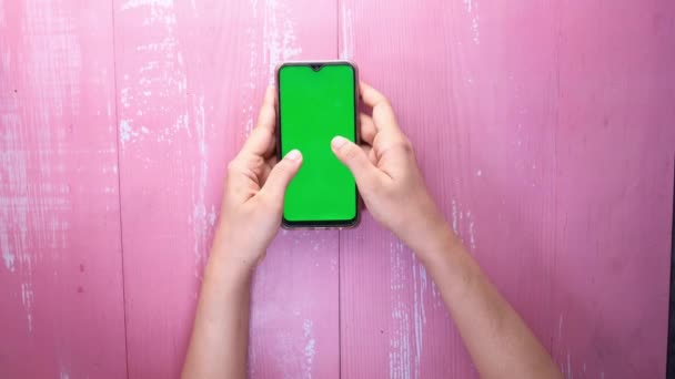 Vista superior de la mano de las mujeres utilizando el teléfono inteligente con pantalla verde — Vídeos de Stock