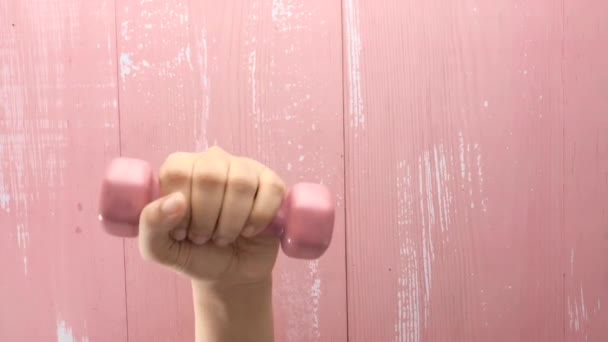 ピンクのダンベルを持つ女性の手のトップビュー. — ストック動画