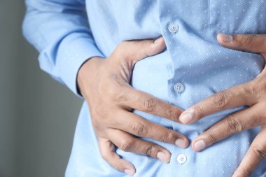 Adam karnına dokunuyor. Acı çekiyor..