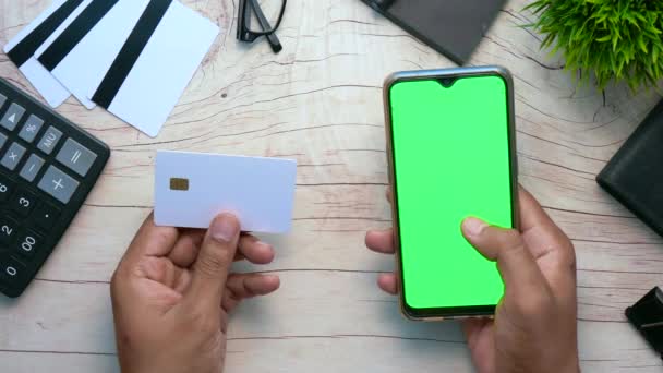 Hombre mano celebración de la tarjeta de crédito y el uso de compras de teléfonos inteligentes en línea — Vídeos de Stock