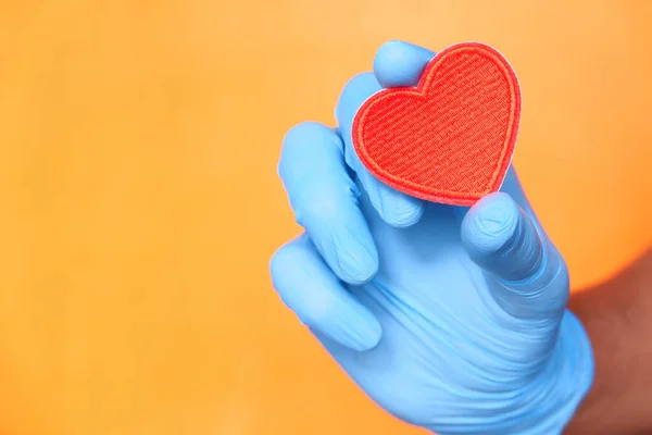 Man hand in protective gloves holding red heart Royalty Free Stock Photos