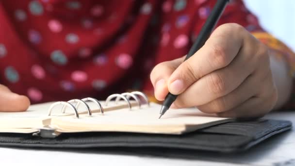 Gros plan des femmes écriture à la main sur le bloc-notes. — Video