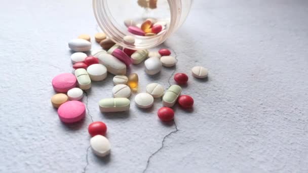Close up de pílulas coloridas derramamento no fundo branco — Vídeo de Stock