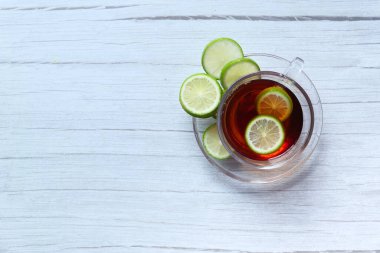 Ahşap zemin üzerinde limon çayı manzarası.