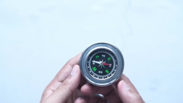 Hand holding compass on a white background — Stock Video