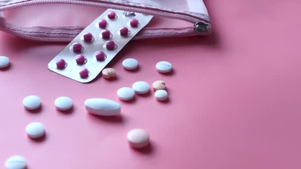 Закрыть таблетки проливая на розовый фон — стоковое видео