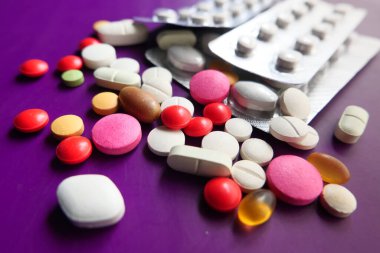 Mor arkaplana dökülen renkli hapları kapat 