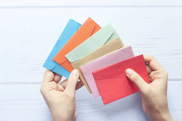 Liefdesbrief in vrouwen hand op rode achtergrond, Bovenaanzicht. — Stockfoto