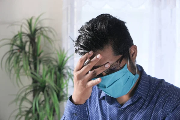 Een jonge zakenman met een beschermend masker in het gezicht ziek voelen — Stockfoto